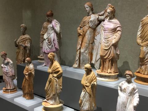 A collection of small statues of ancient women in various poses